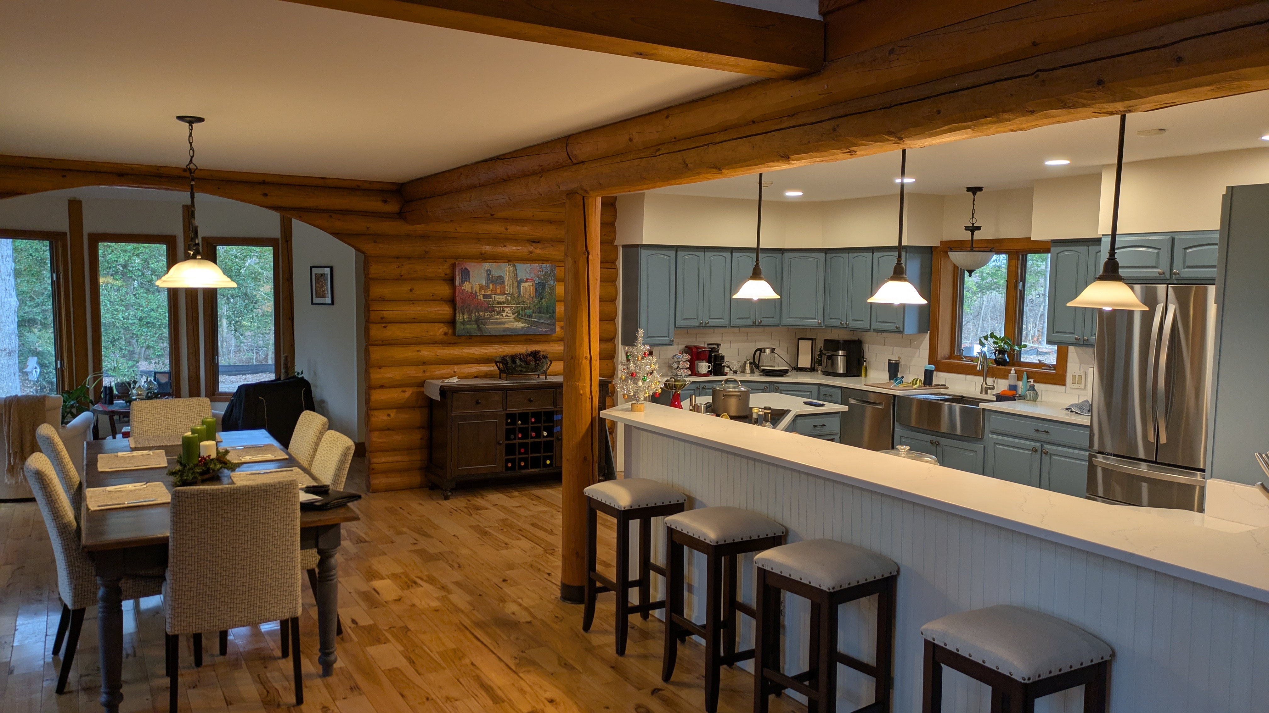 Interior of log cabin showing open kitchen and dining area. 