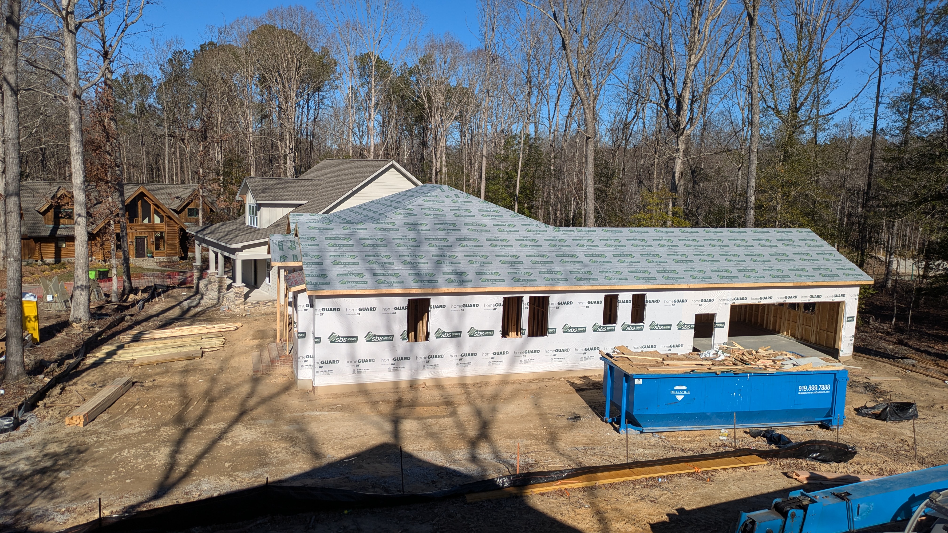 View from second floor of lot 2 showing house on lot 4 framed and wrapped in house wrap. Lot 5 is in the background completely roofed and sided. 